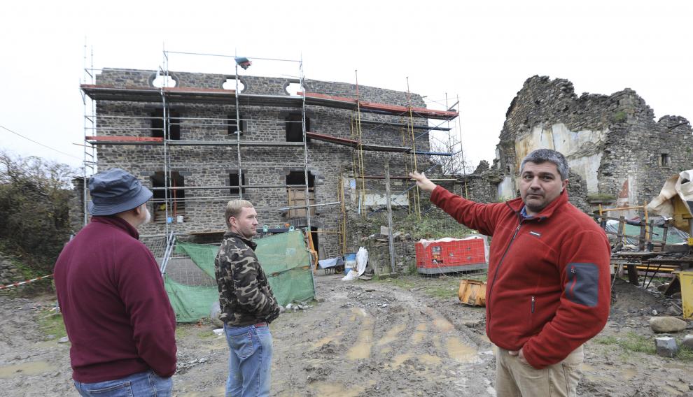 Óscar Espinosa, con Javier y Jesús Garcés, delante de la casa que construye el primero