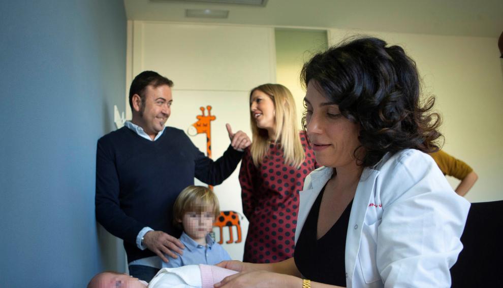 La jefa de la Unidad de Arritmias del Hospital Sant Joan de Dèu, Georgina Sarquella, revisa a María ante sus padres y su hermano mayor.