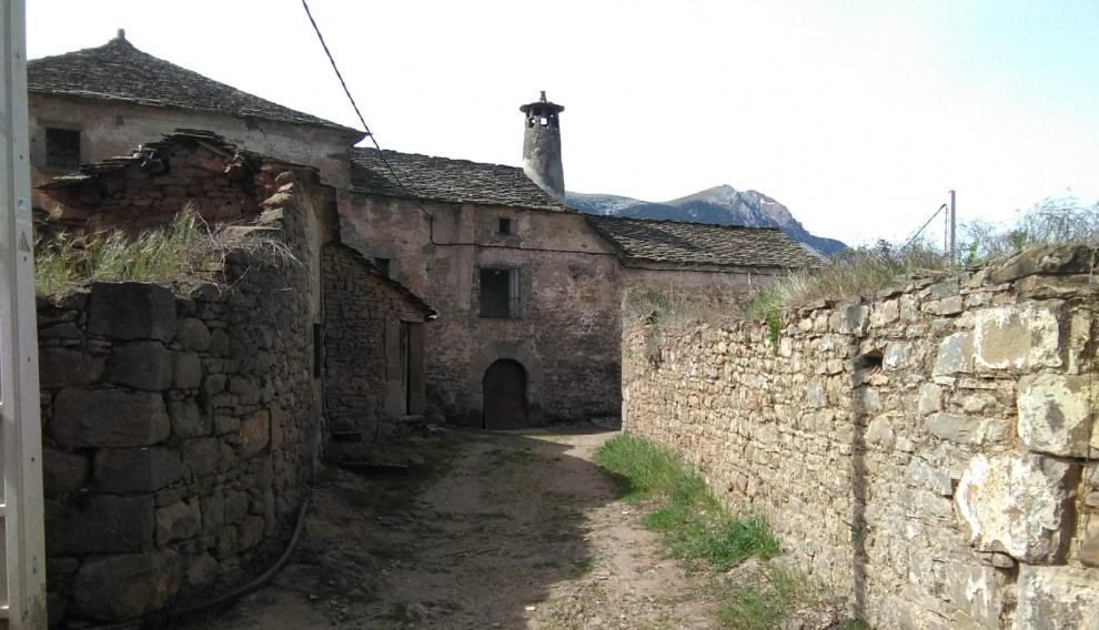 Una de las calles del pueblo y una vivienda con la tradicional chimenea.