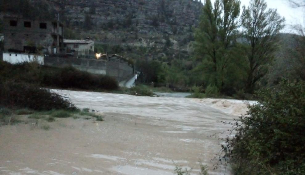 Los vecinos del barrio de los Tarrasones, incomunicados por la crecida del río Mijares a su paso por la localidad turolense de Olba.