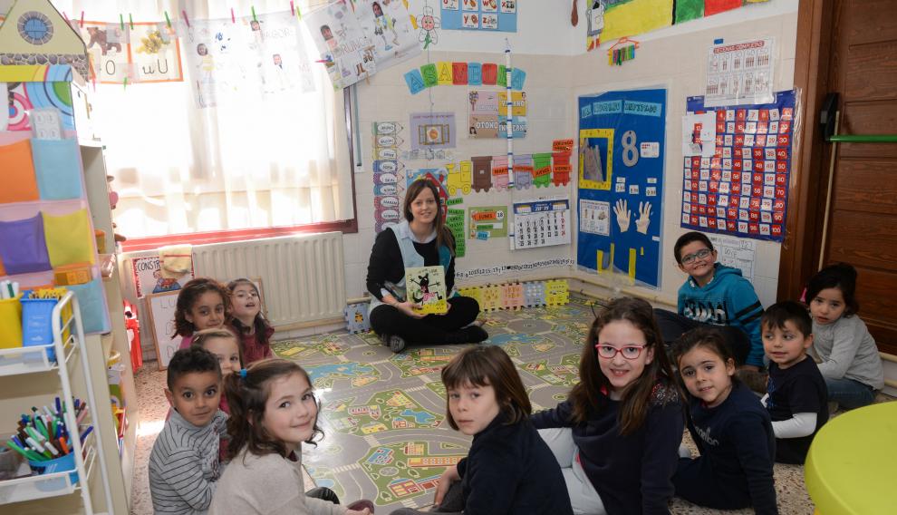 Sara Martí sentada con sus alumnos, en el aula de Valdeltormo del CRA Matarraña (Teruel), a punto de comenzar la maravillosa aventura de leer