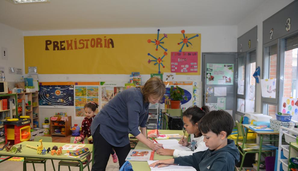 Mariví con sus tres alumnos trabajando en el aula.