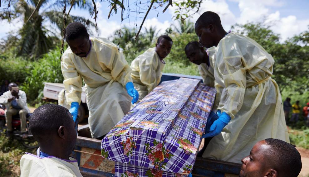 Varios trabajadores sanitarios entierran el cadáver de un hombre que se infectó con ébola tras compartir habitación con un paciente enfermo en Beni (Congo).