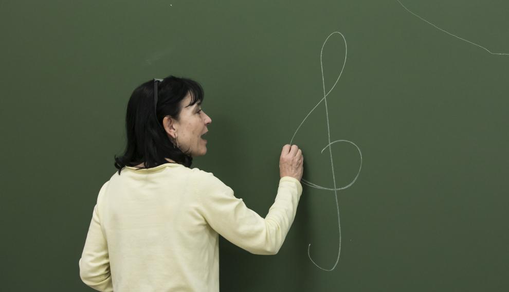 Isabel Zamora, dibujando la clave de sol, en la pizarra