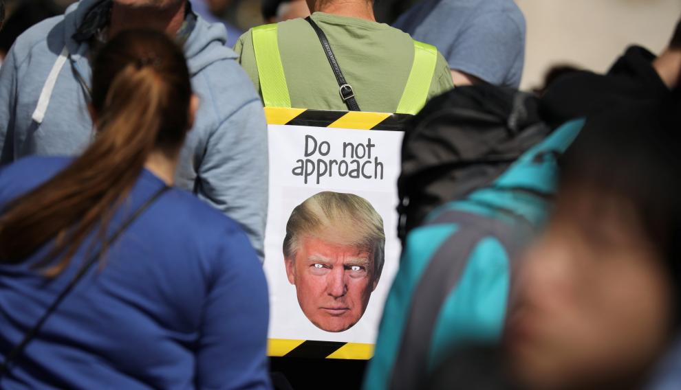 Varias personas esperan la llegada del presidente estadounidense Donald Trump en frente del Buckingham Palace de Londres.