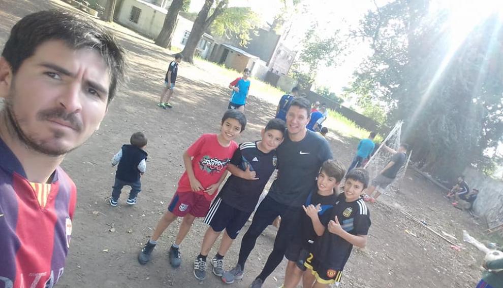 Damian Musto, al fondo, con varios de los niños con los que jugó a fútbol.
