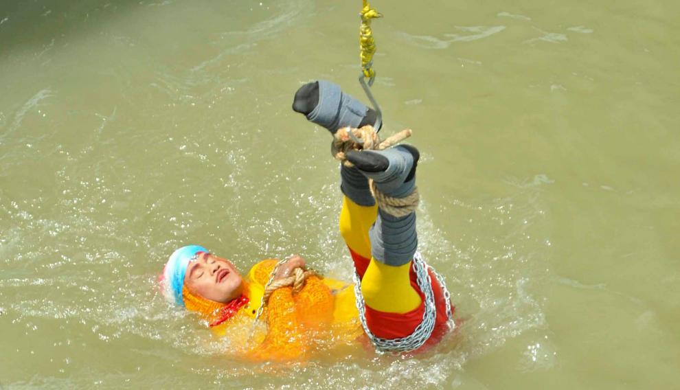 Chanchal Lahiri, conocido como el mago Mandrake, sumergiéndose encadenado en las aguas del Ganges
