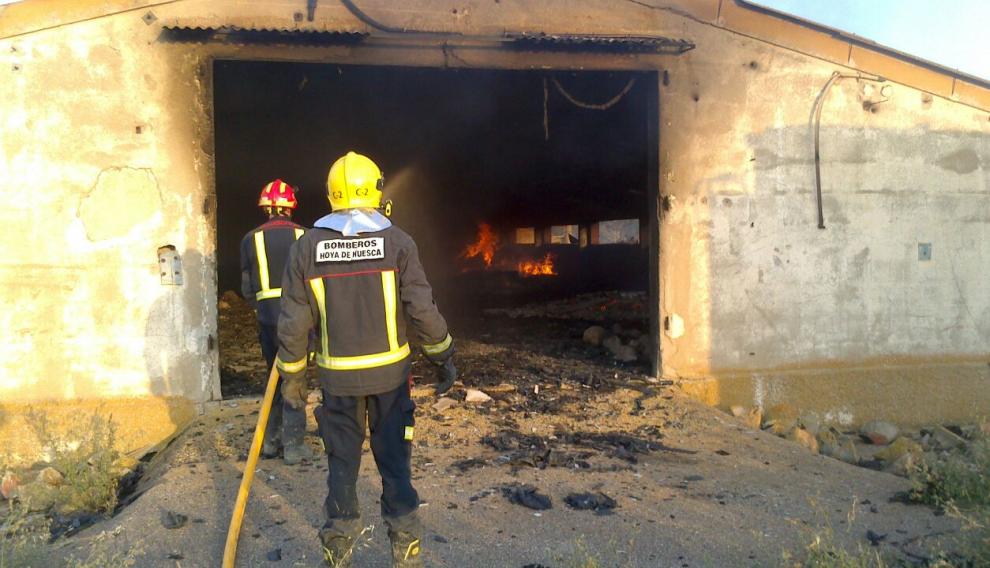 Bomberos en una de las naves agrícolas afectadas por el fuego.