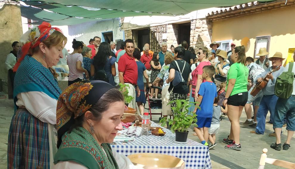 Una mujer, con la capoladora de la carne, en la feria de oficios antiguos de Lituénigo