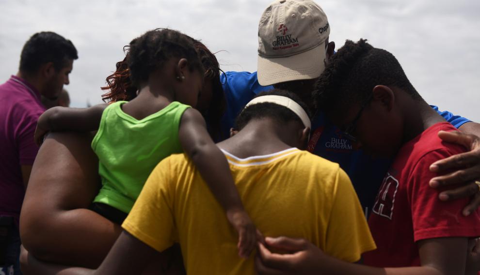 Varios familiares orando en el memorial a las víctimas, tres días después de la matanza en El Paso.