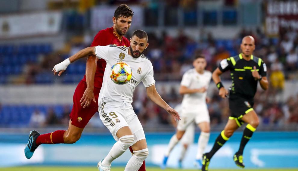 Benzema intenta marcharse del jugador de la Roma Fazio.