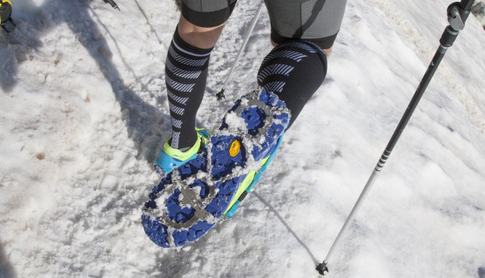 Crampones colocados en una zapatilla de trail.