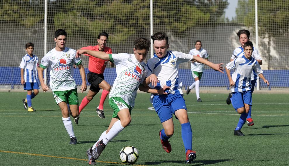 Un jugador del Peñas Oscenses conduce ante la presión de un rival ejeano.