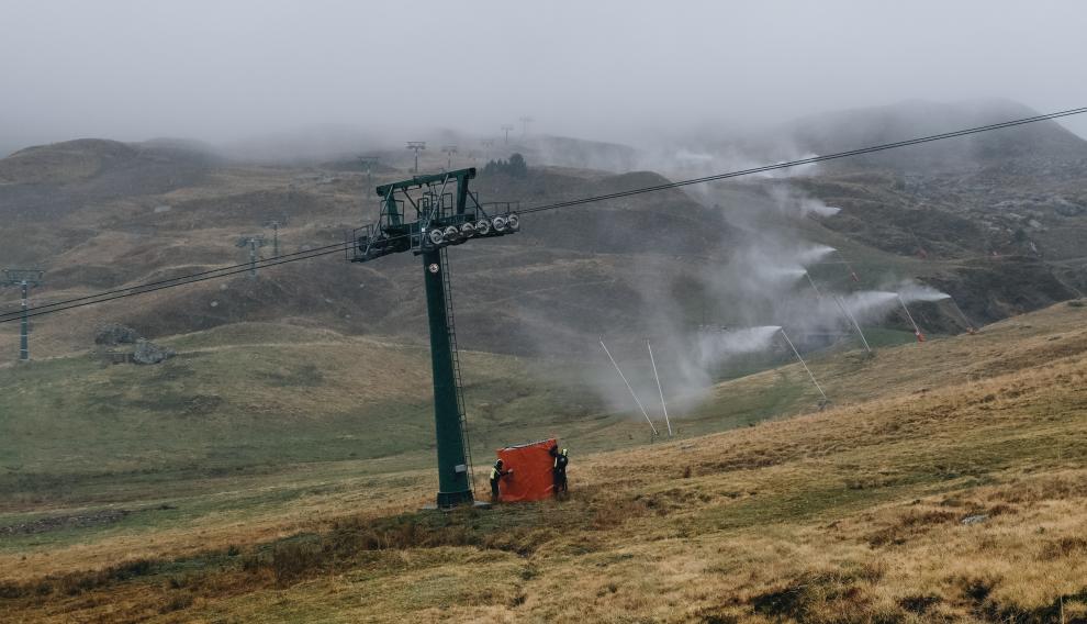 Trabajadores de Formigal colocan colchonetas de seguridad y al fondo, pruebas de los cañones.