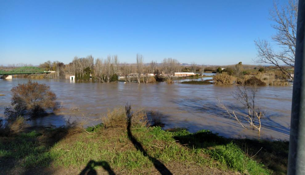 Vista del puente de Hierro de Gallur, con el Ebro desbordado. Al fondo, a la derecha, la carretera A-127, cortada por el agua.