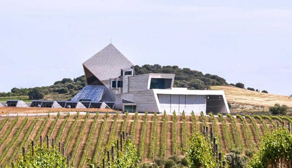 El imponente perfil de la Bodega Sommos, rodeada de viñedos.