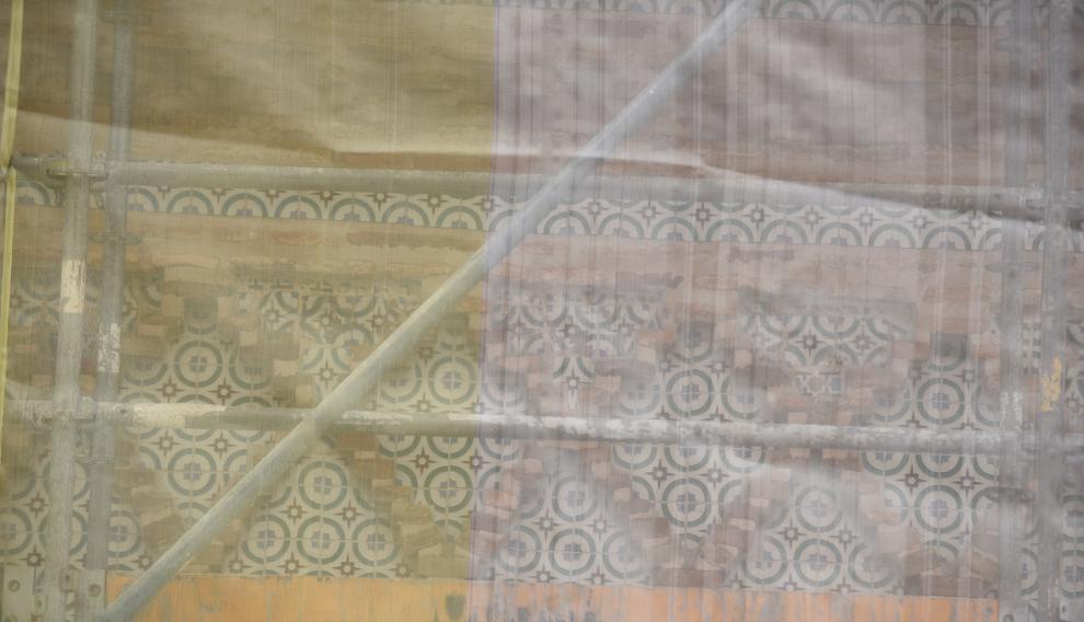 Algunos de los azulejos que se observan a través de los andamios y de la lona.