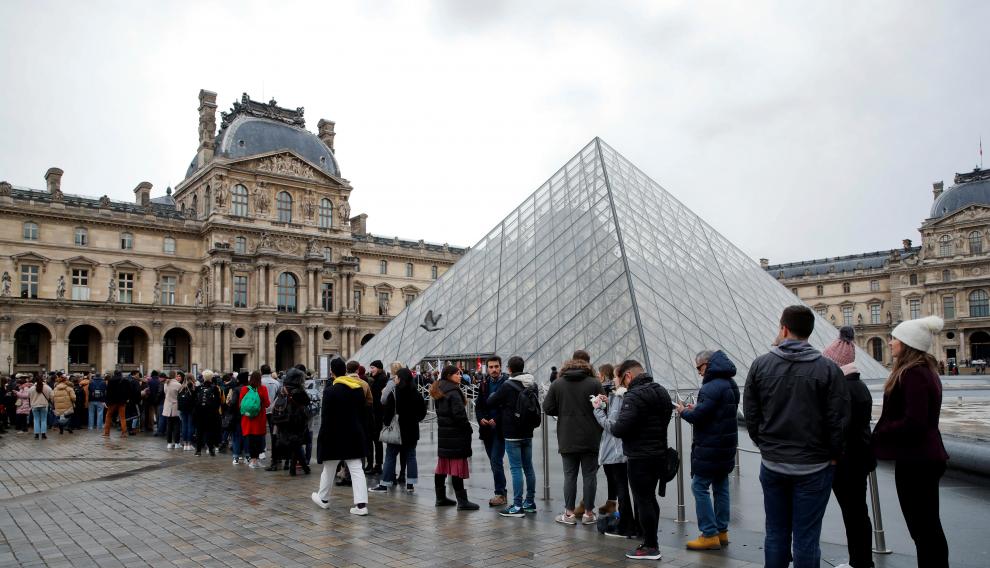 Turistas hacen fila en los alrededores del Museo de Louvr, en París.