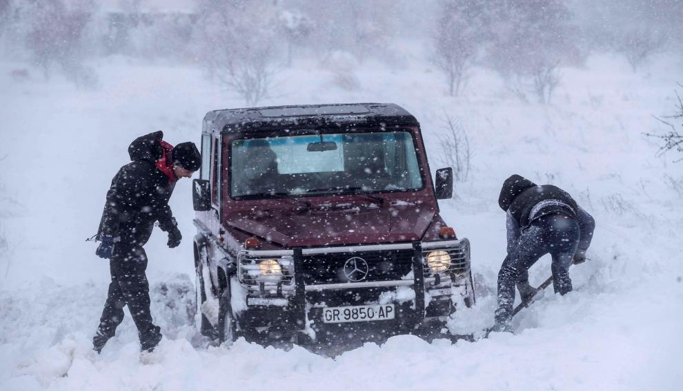 Dos hombres intentan sacar su todoterrreno atrapado en la nieve en las proximidades de Yecla (Murcia)