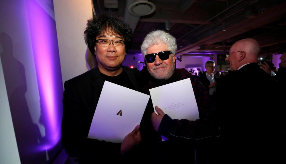Bong Joon Ho y Pedro Almodovar, rivales y amigos, en una fiesta tras la ceremonia, muestan sus certificados de nominados.