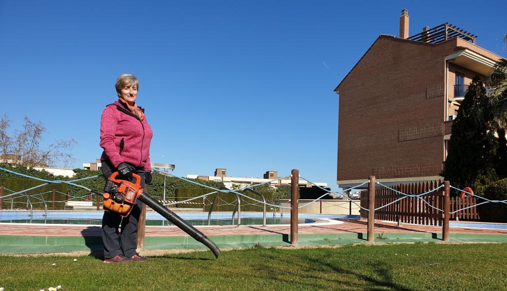 La conserje María José Sáez cuida el césped de la urbanización donde trabaja.