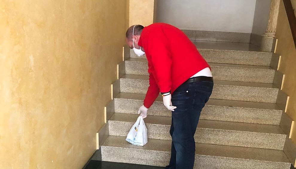 Un voluntario deja una bolsa con medicamentos en una casa del Bajo CInca