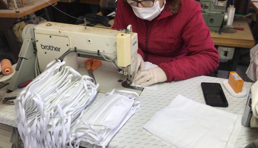 Una vecina de Fuentespalda confecciona mascarillas en su casa.