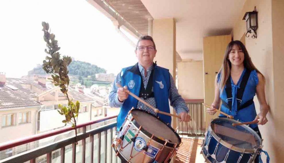 Dos alcañizanos tocan el tambor desde el balcón de su casa durante el confinamiento