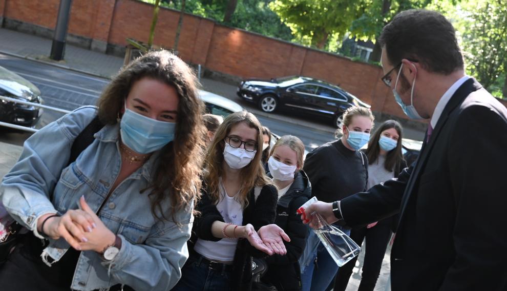 27 April 2020, Hessen, Frankfurt: A teacher sprays hand disinfectant on the hands of the students before entering the school as particular pupils are back in school after a six-week break. Photo: Arne Dedert/dpa27/04/2020 ONLY FOR USE IN SPAIN [[[EP]]] 27 April 2020, Hessen, Frankfurt: A teacher sprays hand disinfectant on the hands of the students before entering the school as particular pupils are back in school after a six-week break. Photo: Arne Dedert/dpa