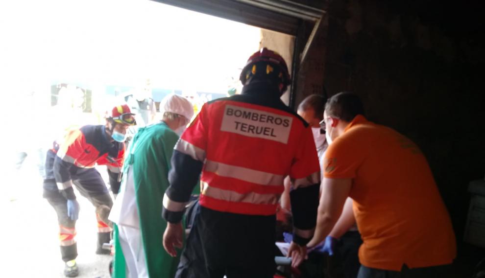 Personal sanitario atiende al operario que ha caído en un algibe en Alloza mientras los bomberos esperan para trasladarlo