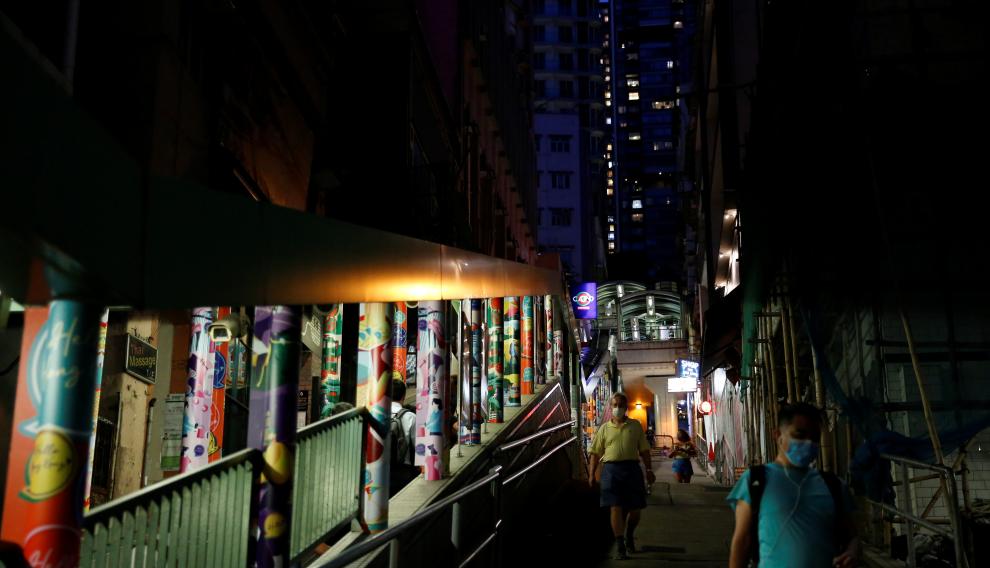 People wearing protective face masks walk at Mid-Levels Central, following the coronavirus disease (COVID-19) outbreak in Hong Kong