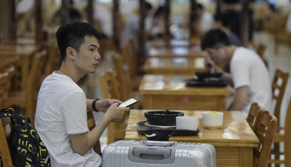 Estudiantes comen en una mesa del campus de la Universidad de Ciencia y Tecnología de Huazhong en Wuhan