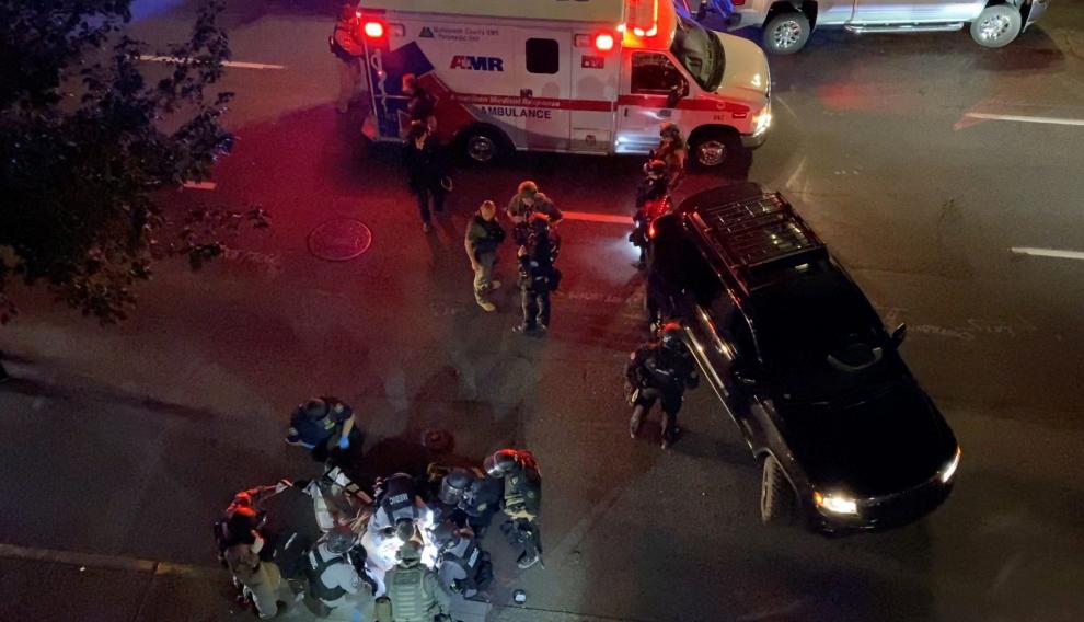 Video grab of medics and police personnel with the victim of a shooting in Portland, U.S.