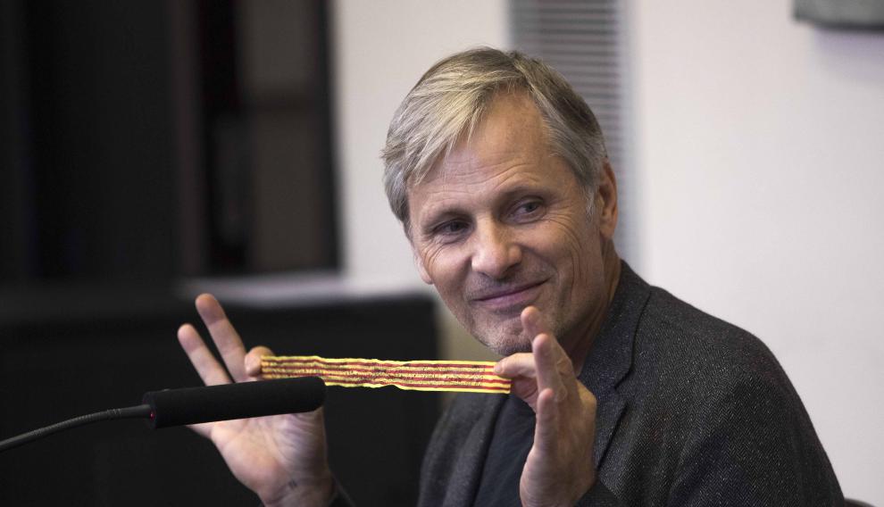Viggo Mortensen muestra una medida de la Virgen del Pilar.