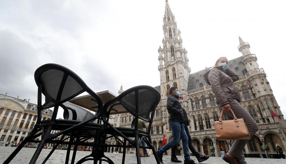 Varias personas pasean por la Grand Place de Bruselas.