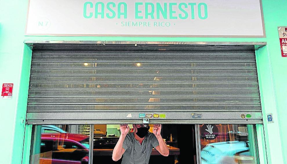 Javier Martín, echando el cierre de su negocio este lunes.