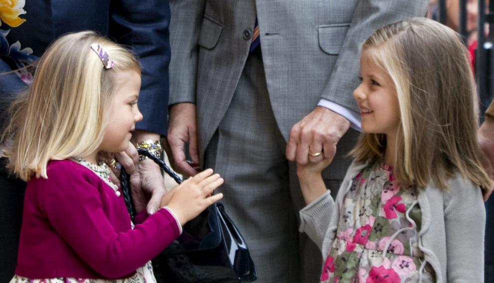 La infantas Leonor y Sofía de la mano de su padre, Felipe VI, a las puertas de la catedral de Mallorca el Domingo de Resurrección de 2011