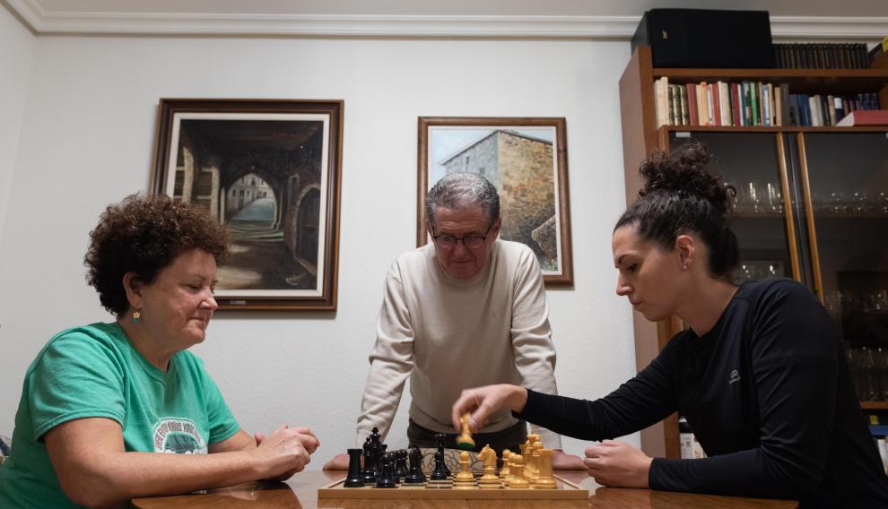 Esther Ballestero, a la derecha, juega contra su madre mientras su padre, también aficionado, observa las estrategias.