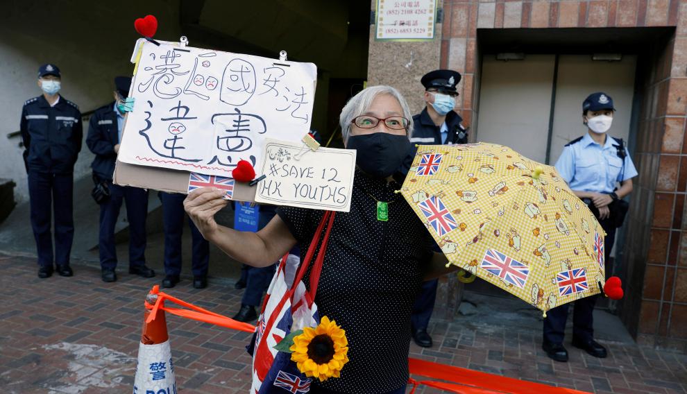 Pro-democracy activist Alexandra Wong holds placards during a protest to urge for the release of 12 Hong Kong activists outside China's Liaison Office, in Hong Kong