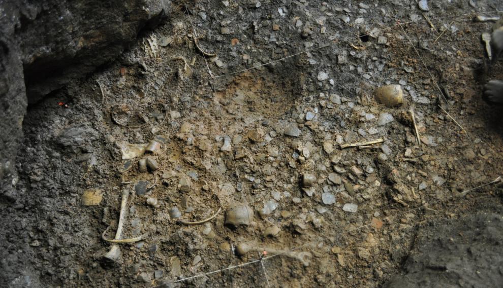 Lecho original del fondo de la cueva con gran concentración de restos humanos, de animales y cerámica
