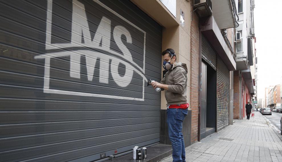 El grafitero Antonio Miró decora una persiana de una empresa en la calle José Pellicer.