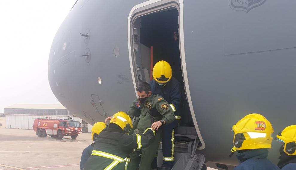 Unos bomberos rescatan a un piloto de la cabina del A400M en un simulacro de emergencia realizado el pasado viernes en la Base aérea de Zaragoza.