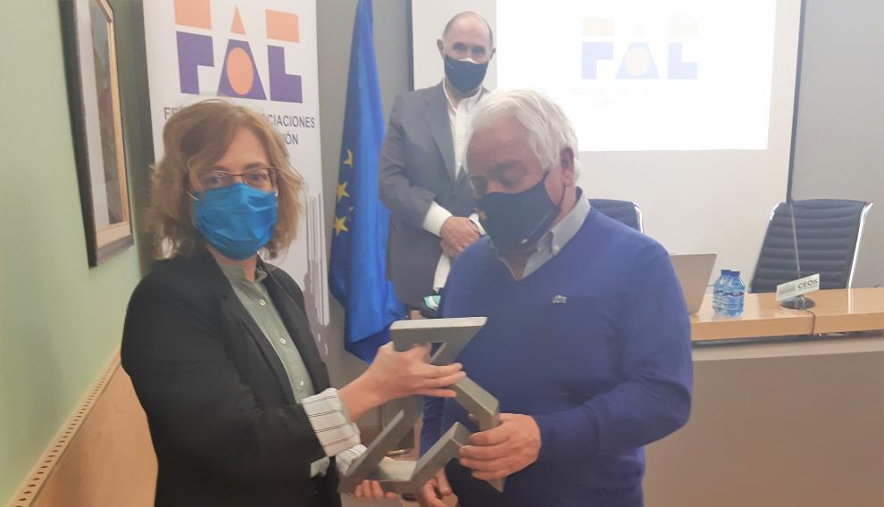 Ana Porta entrega a José Buil una pajarita grabada o reconocimiento de todos sus años como presidente de la FAC.