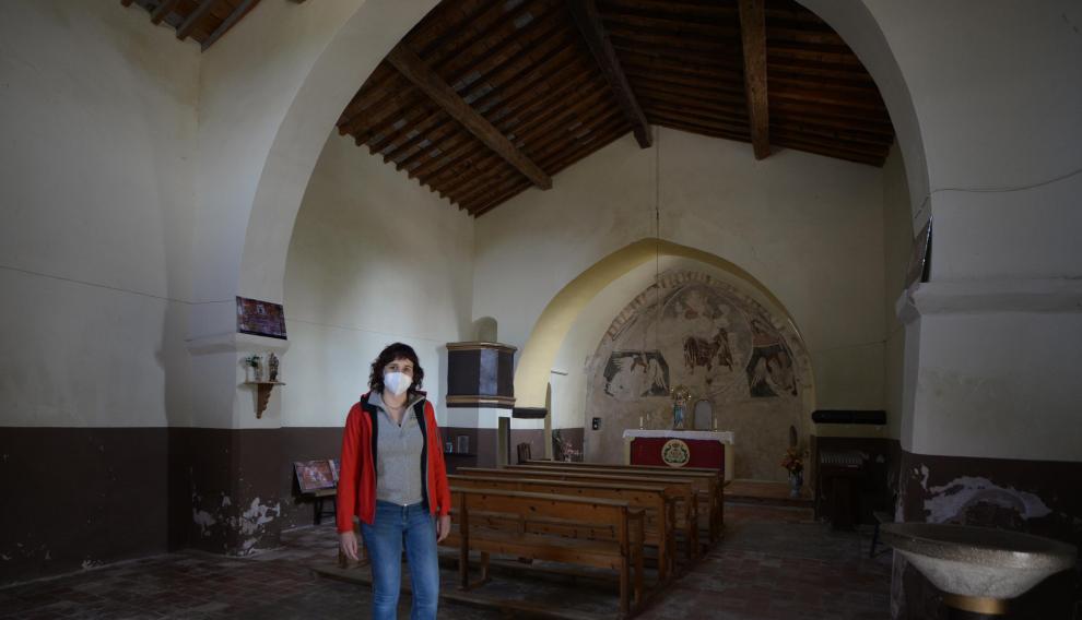 Sara Ros, en el interior de la ermita de Camañas, muestra reproducciones de la decoración de la techumbre.