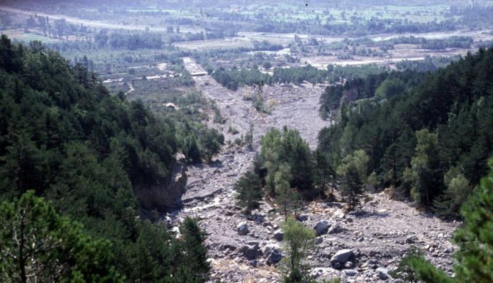 Esta imagen se tomó dos días después de la tragedia. Se ve el cono de deyección donde se asentaba el campin (la masa de árboles a la derecha) y el cauce artificial de comienzos del siglo XX parcialmente relleno de los sedimentos aportados por la avenida.