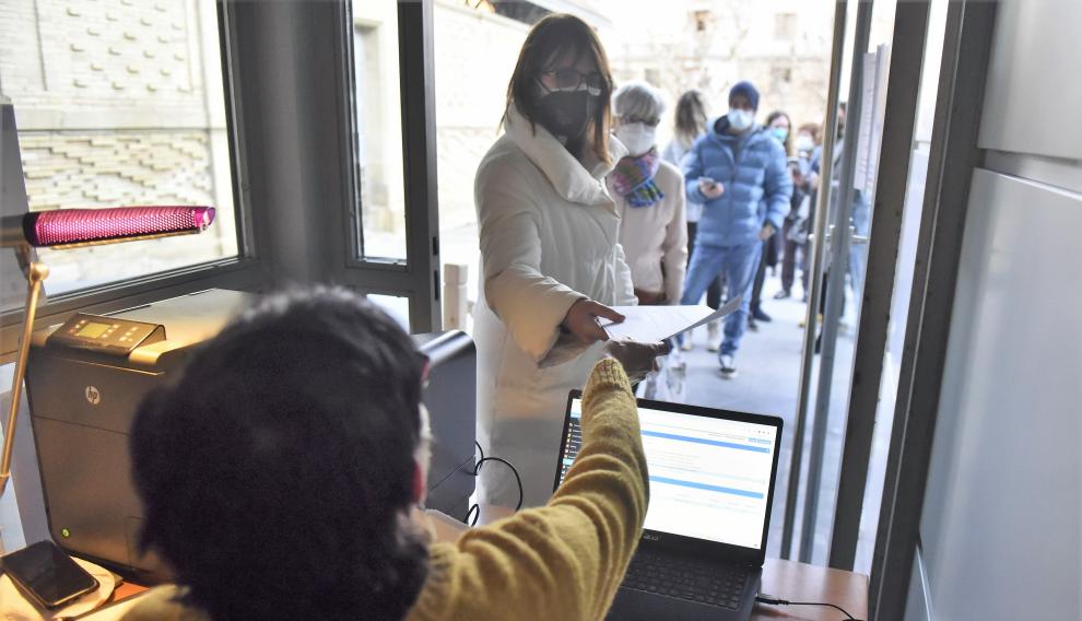 Una mujer recoge la entrada para acceder a la plaza de toros y asistir al saludo de los Reyes.