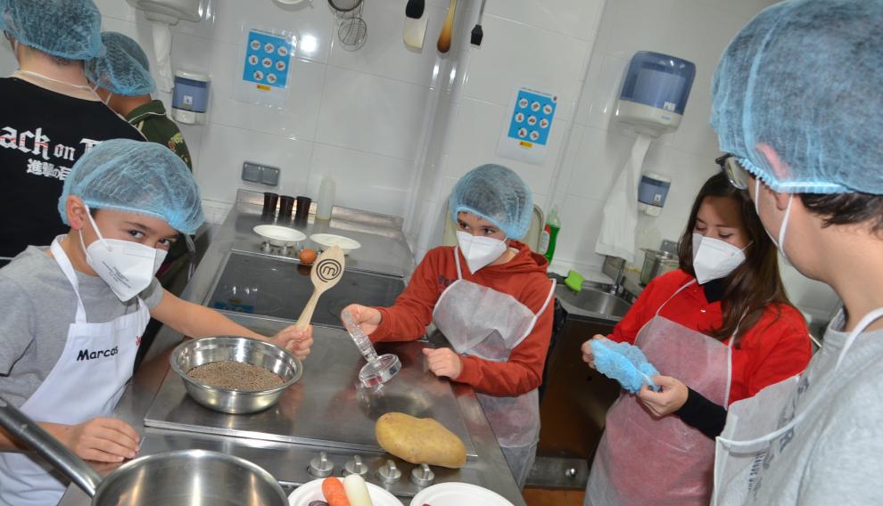 Marcos, Dani, la voluntaria Cristina Morón y Guille, en la cocina de Azafrán.