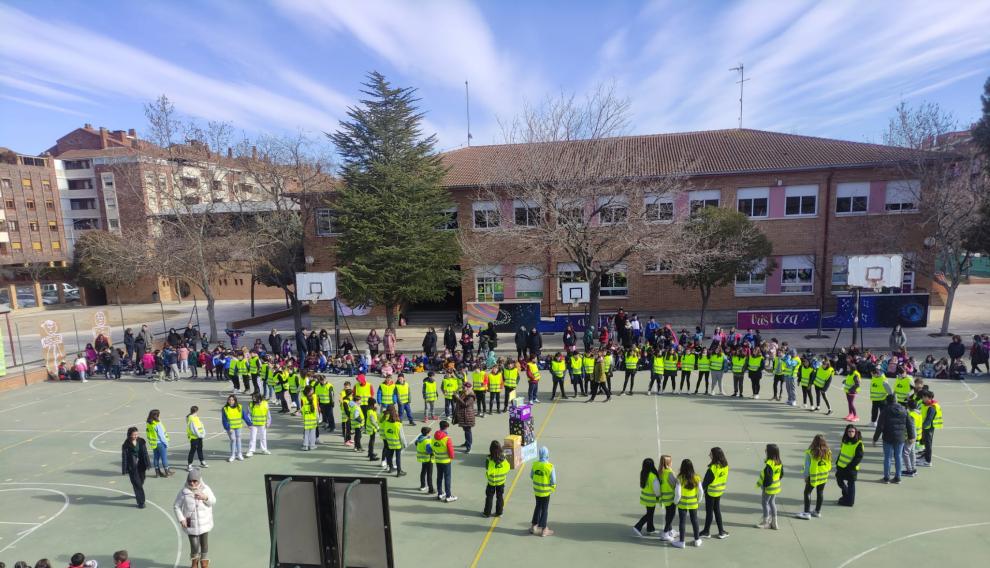 Los alumnos del colegio Pedro J. Rubio de Huesca dibujan un lazo contra el cáncer infantil.