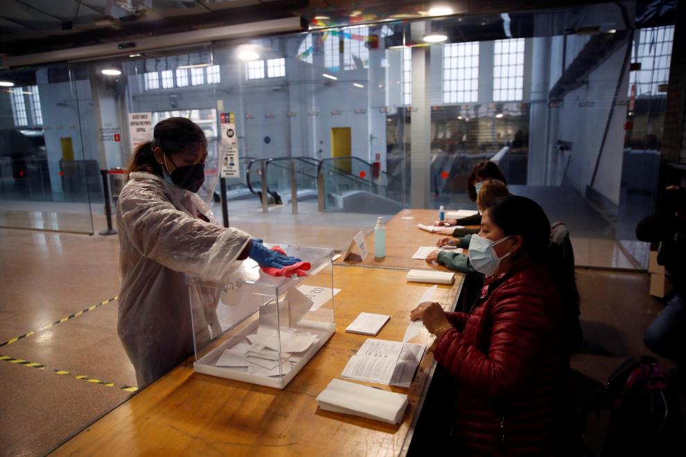 Una mujer limpia una urna en el colegio electoral situado en el Mercat del Ninot en Barcelona.