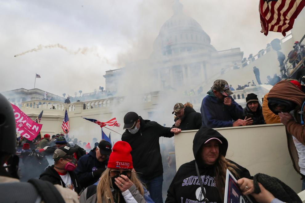 Supporters of U.S. President Donald Trump cover their faces to protect from tear gas during a clash with police officers in front of the U.S. Capitol Building in Washington, U.S., January 6, 2021. REUTERS/Leah Millis[[[REUTERS VOCENTO]]]